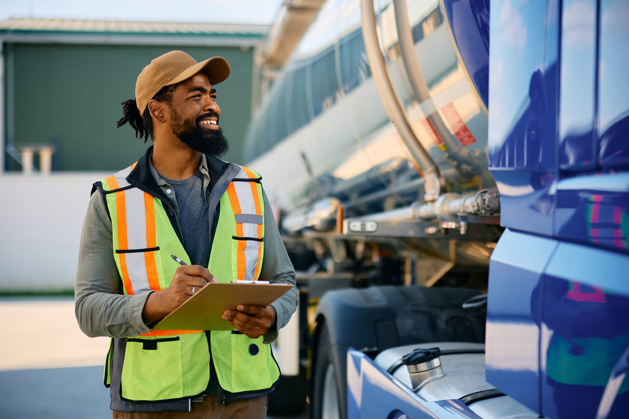 Happy freight transportation dispatcher examining a truck before the ride.