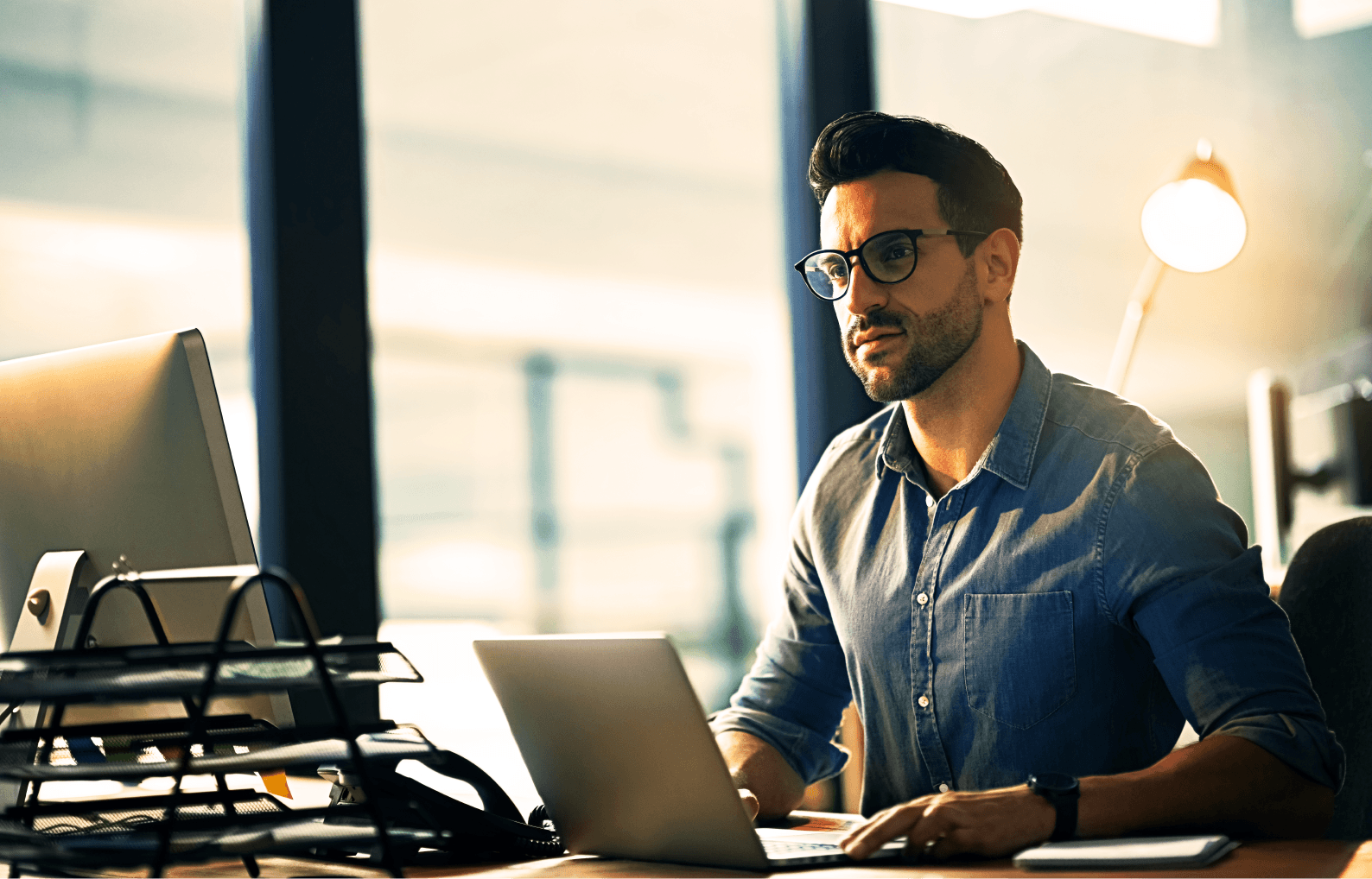 man using his laptop and pc monitor for work